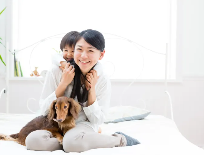 family sitting on bed with dog